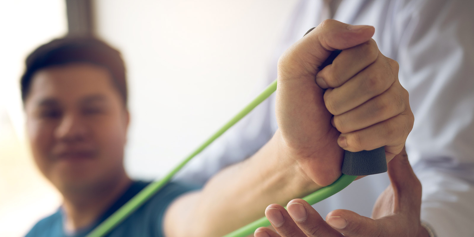 close up hand patient doing stretching exercise with a flexible