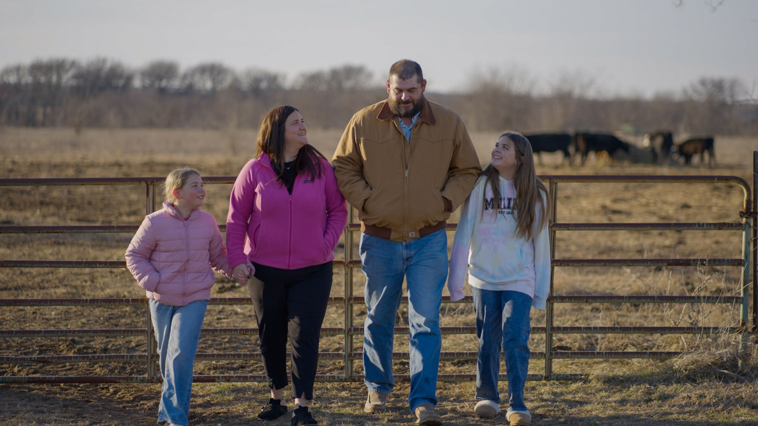 Daves Family walking through a cow pasture